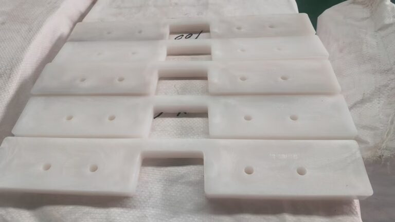 Close-up view of custom UHMWPE drag conveyor flights showing the profile and mounting holes
