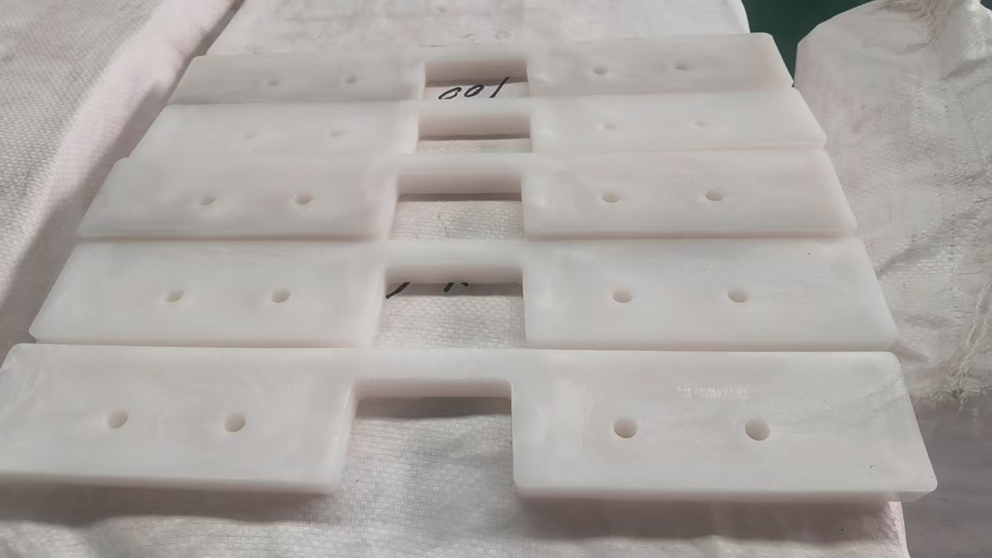 Close-up view of custom UHMWPE drag conveyor flights showing the profile and mounting holes