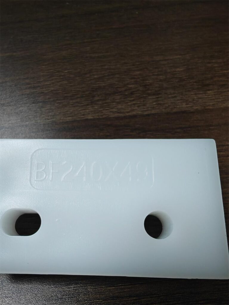 Mounting hole detail of a white HDPE BF plastic conveyor flight